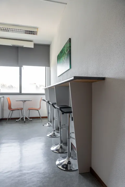 Copa com bancos altos, mesa e cadeiras laranja.