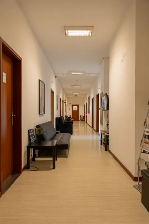 Corredor de acesso aos escritórios, com sofá.