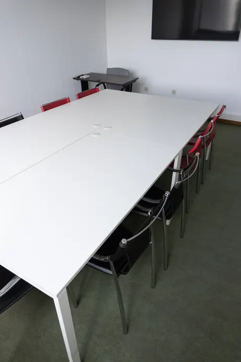 Sala renovada, mesa comprida, cadeiras e televisão.