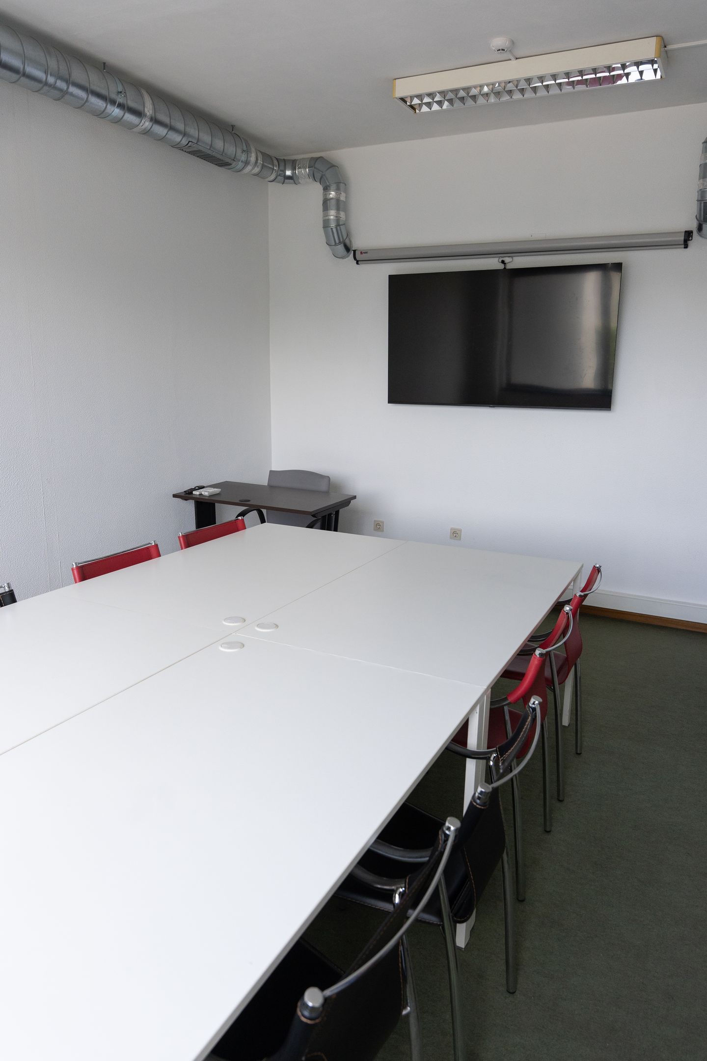 Sala de reuniões renovada, com televisão de 65 polegadas.